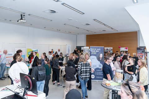 Ein Raum mit Ständen verschiedener sozialer Träger sowie Studierenden. (öffnet Vergrößerung des Bildes)