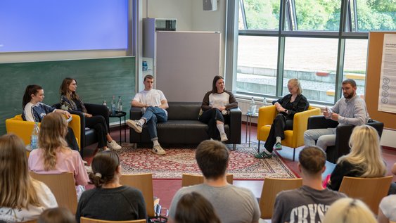 Blick auf die Teilnehmenden der Podiumsdiskussion aus Sicht des Publikums.