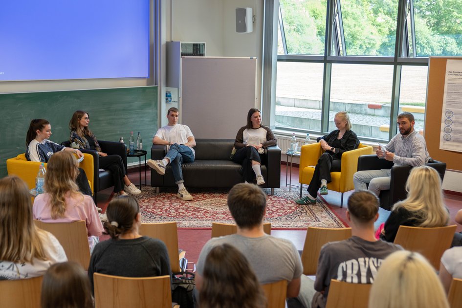 Blick auf die Teilnehmenden der Podiumsdiskussion aus Sicht des Publikums.