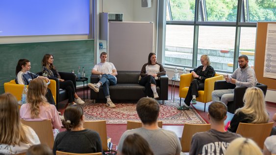Blick auf die Teilnehmenden der Podiumsdiskussion aus Sicht des Publikums.