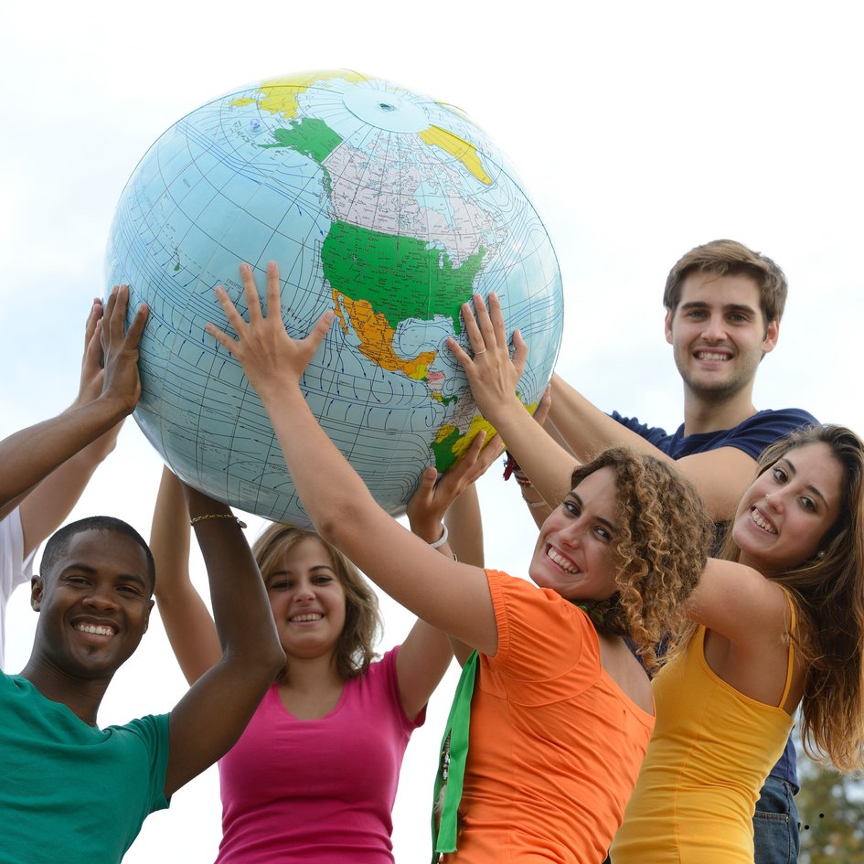 Sechs Studierende, die sich freuen und einen Weltkugel-Ball halten. (öffnet Vergrößerung des Bildes)