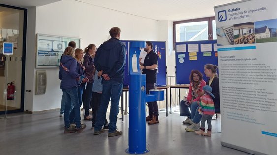 Besucher:innen stehen am Stand der Fakultät Soziale Arbeit und informieren sich über das Studienangebot.