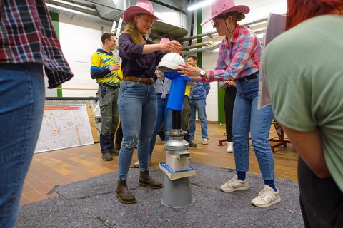 Zwei Studierende stapeln Ingenieursgegenstände so an, dass sie ausbalanciert sind. (öffnet Vergrößerung des Bildes)