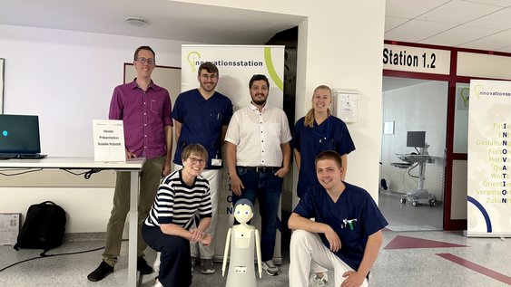 Prof. Dr. Tobias Dörnbach (oben links) und Prof. Dr.-Ing. Dagmar Meyer (unten links) besuchten mit dem sozialen Roboter Momo (unten Mitte) das Klinikum Wolfenbüttel.