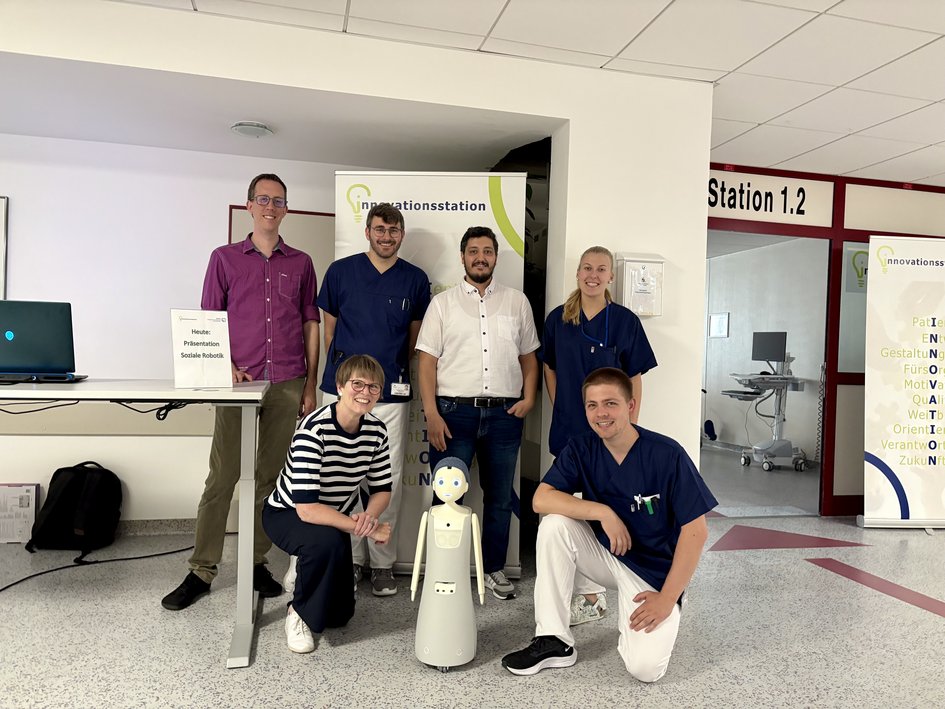 Prof. Dr. Tobias Dörnbach (oben links) und Prof. Dr.-Ing. Dagmar Meyer (unten links) besuchten mit dem sozialen Roboter Momo (unten Mitte) das Klinikum Wolfenbüttel.