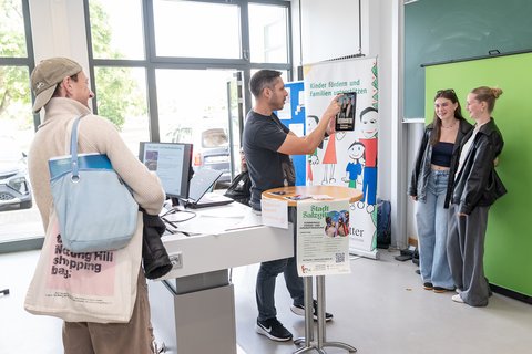 Zwei Studierende stehen vor einem Greenscreen und lassen sich im Rahmen eines Angebotes fotografieren. (öffnet Vergrößerung des Bildes)