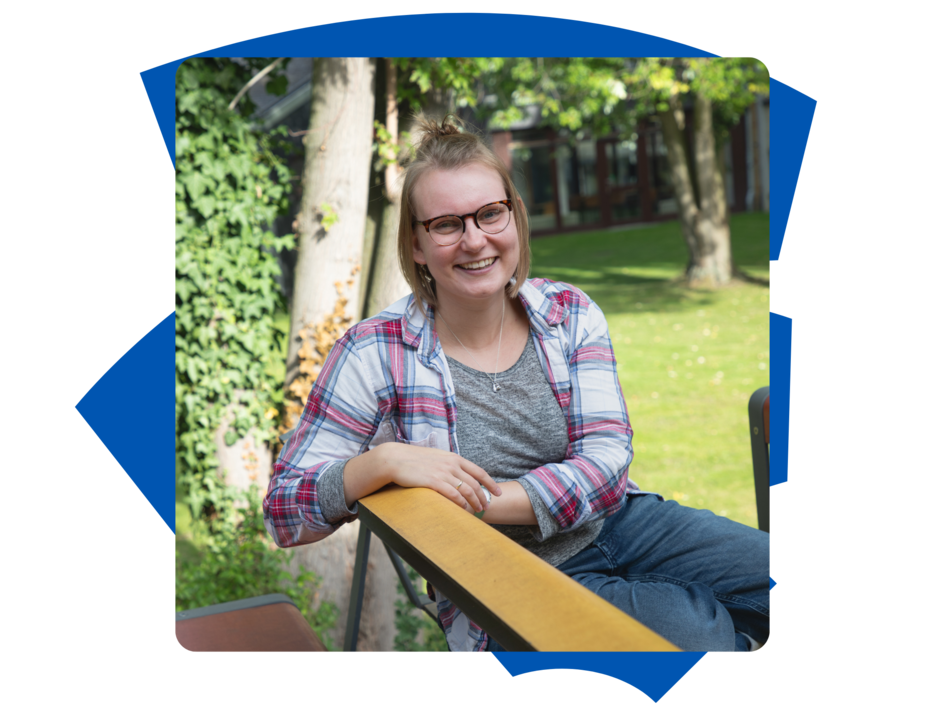 Studentin Stephi der Fakultät Versorgungstechnik sitzt draußen auf der Bank am Campus Wolfenbüttel und schaut in die Kamera.