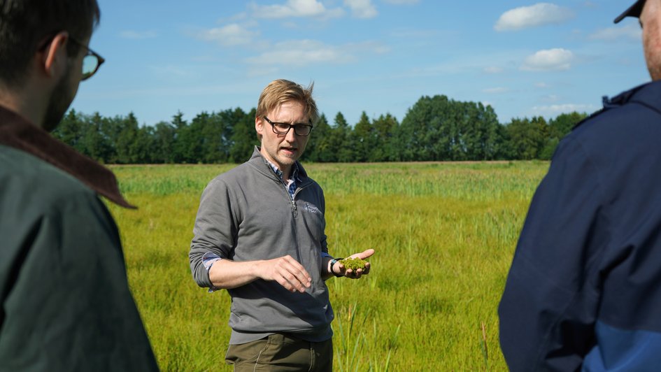 Marten Beiermann von der ZukunftMoor Gnarrenburg GmbH im Austausch mit den Teilnehmenden während der Exkursion im Gnarrenburger Moor. Foto: Marie Ruhm/Ostfalia