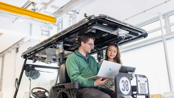 Professor arbeitet mit einer Studierenden am Laptop im Labor.