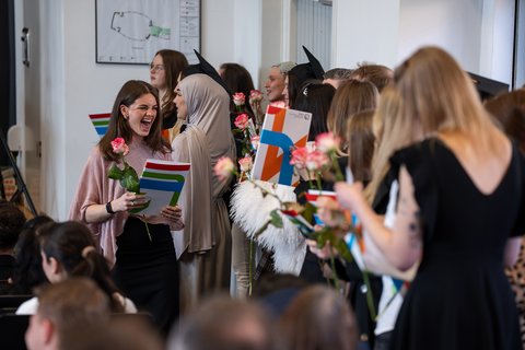 Eine Absolventin freut sich sichtlich über die erhaltene Urkunde. (öffnet Vergrößerung des Bildes)