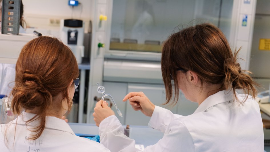 Schüler*inn und B.Eng. Sophie Schmechel im Chemielabor. Sie bauen eine Batterie.