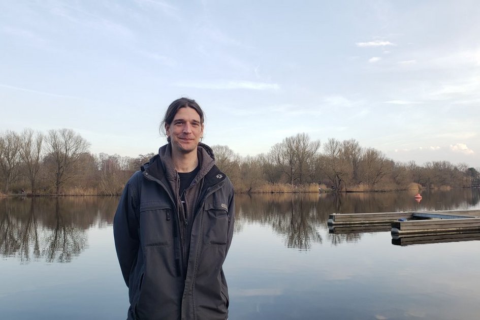 Student Jacobo Coxall steht vor einem See