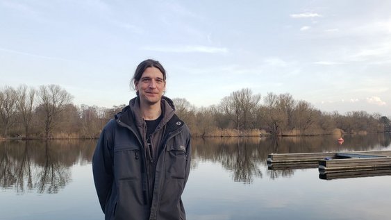 Student Jacobo Coxall stands in front of a lake