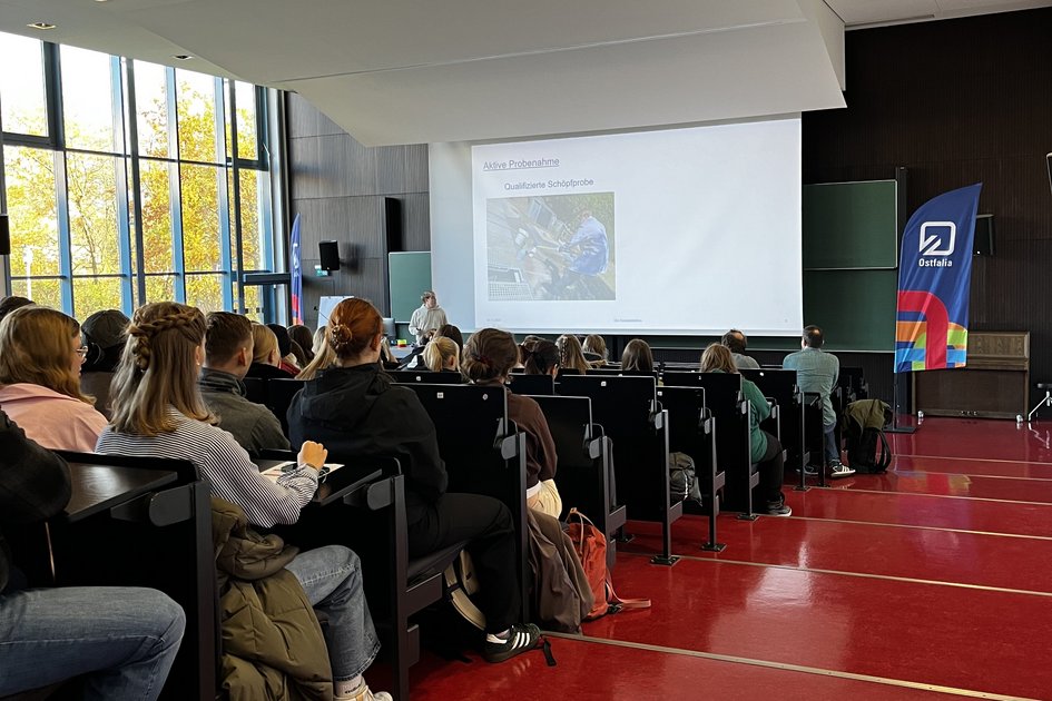 Schülerinnen uns Schüler hören im Audimax einem Vortrag zu.