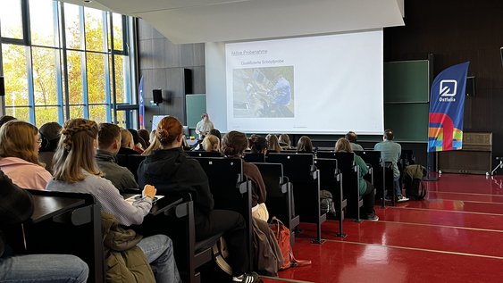 Schülerinnen uns Schüler hören im Audimax einem Vortrag zu.