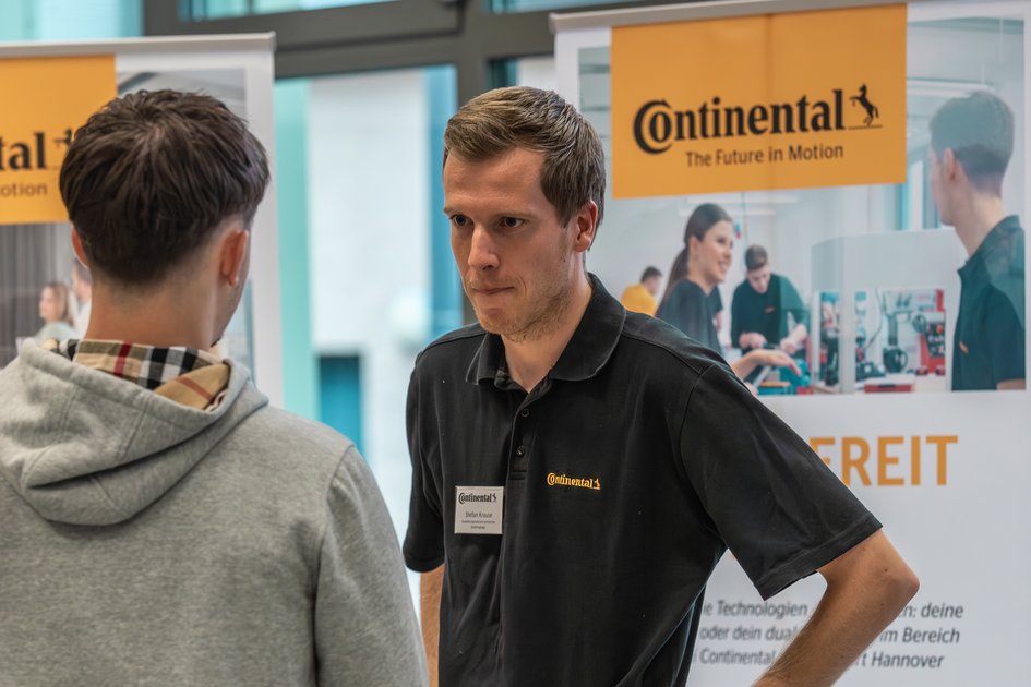 Ein Studieninteressierter unterhält sich an der Ostfalia Hochschule mit einem Vertreter der Continental AG.