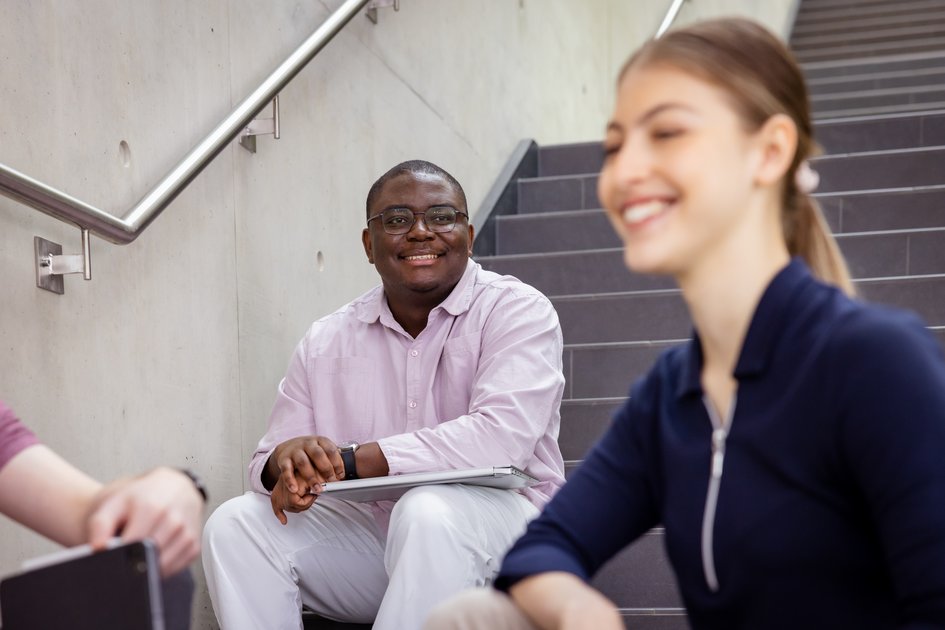 Studierende sitzen auf der Treppe