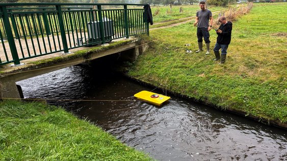 Jasper Seng (links im Bild) und Olaf Baalhorn (rechts im Bild) führen gemeinsam eine Durchflussmessung durch. Während sie das ADCP-Messgerät im Wasser positionieren, überprüfen und steuern sie die Messung über das angeschlossene Bedienteil. Foto: Marie Ruhm/Ostfalia
