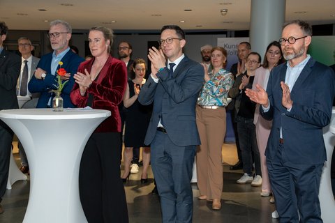 Dr. Thomas Beitin, Falko Mohrs und Prof. Dr. Julia C. Arlinghaus applaudieren beim Hochschulempfang für den Wissenschaftsrat im Kunstmuseum Wolfsburg. (öffnet Vergrößerung des Bildes)