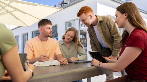 Fünf Studierende der Ostfalia Hochschule lernen gemeinsam mit Büchern und iPads am Campus Wolfsburg. Sie nutzen dazu eine Dachterrasse.