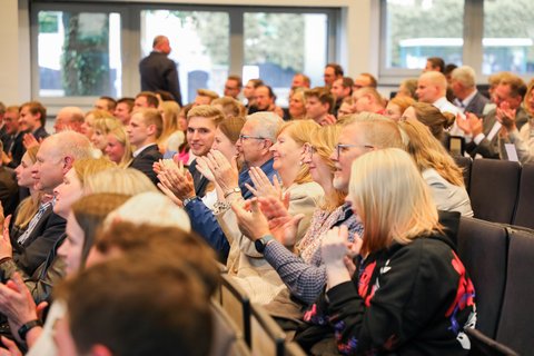Aufnahme von der Absolventenfeier, wie die Gäste applaudieren. (öffnet Vergrößerung des Bildes)