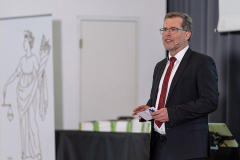 Prof. Dr. Litschen bei der Begrüßung zur Abschlussfeier. Er hält eine Moderationskarte in der Hand. (öffnet Vergrößerung des Bildes)