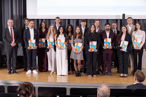 Gruppenbild der anwesenden Absolventinnen und Absolventen des Bachelor-Studiengangs Wirtschaftsrecht auf der Bühne. (öffnet Vergrößerung des Bildes)