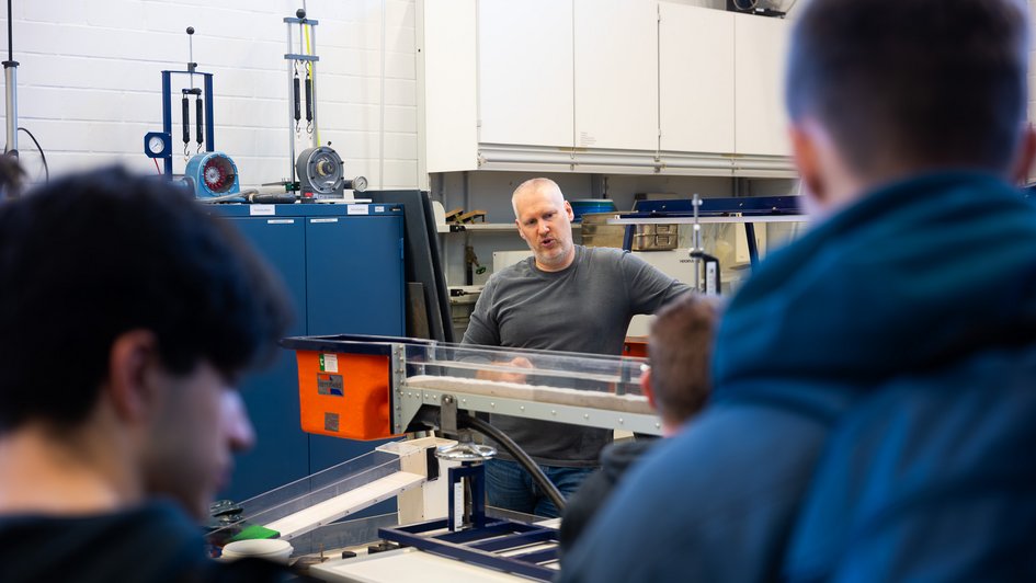 Nach der Einführungen mit vielen Praxisbeispielen in der Veranstaltung „Naturnaher Wasserbau“ gibt Prof. Dr.-Ing. Thorsten Albers in der Wasserbauversuchshalle vertiefende Einblicke zur Möglichkeit der wissenschaftlichen Bewertung der vorgestellten Maßnahmen.