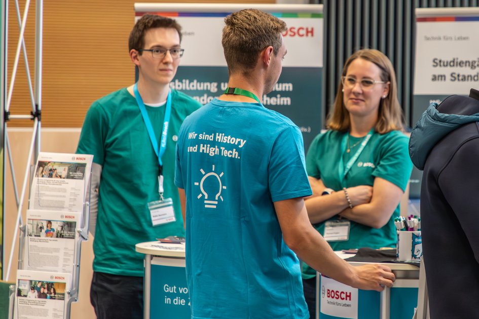 Studieninteressierte sprechen an der Ostfalia Hochschule mit Unternehmensvertretern. Am Campus Wolfenbüttel kann man uner anderem Digital Engineering Maschinenbau im Praxisverbund studieren.