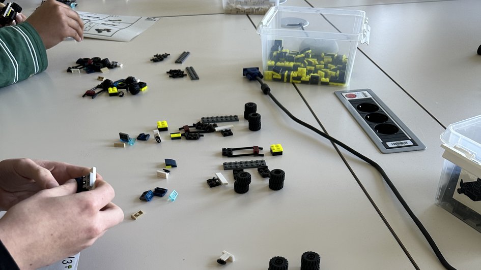 Schülerinnen bauen Rennautos zusammen (öffnet Vergrößerung des Bildes)