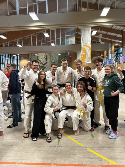 Judoka der Ostfalia und TU Braunschweig posieren gemeinsam mit Unterstützenden in einer Sporthalle und feiern den dritten Platz bei der Deutschen Hochschulmeisterschaft im Judo. (öffnet Vergrößerung des Bildes)