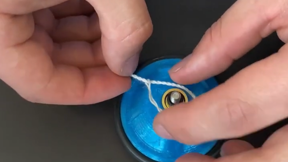 Eine Person baut ein Yoyo zusammen. 