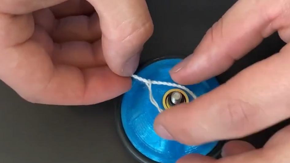 Eine Person baut ein Yoyo zusammen. 