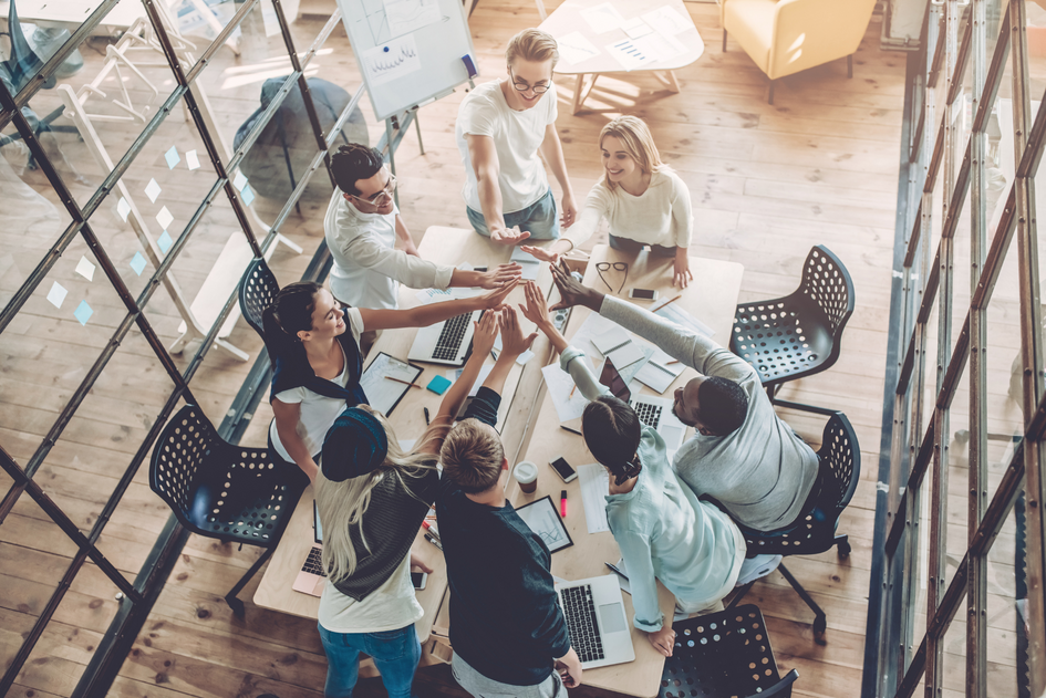 Eight young people working in a team in a workspace.