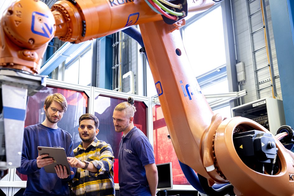 Drei Studenten der Ostfalia Hochschule steuern einen Roboterarm. Am Campus Wolfenbüttel kann man u.a. Wirtschaftsingenieurwesen Maschinenbau im Praxisverbund studieren.