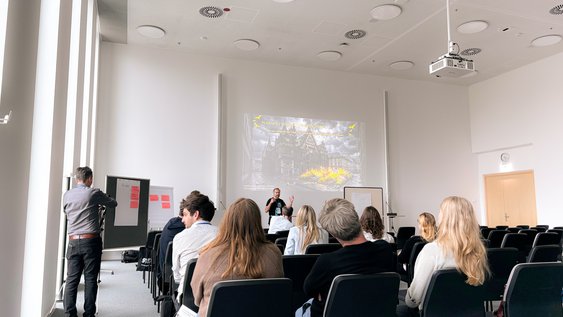 Prof. Dr.-Ing. Jan Büchsenschuß und Student Hendrik Pergande auf der Bühne des Workshops " Verwaltungspingpong. Wie man ein Smart City Projekt erfolgreich durch eine Kommunalverwaltung bekommt"