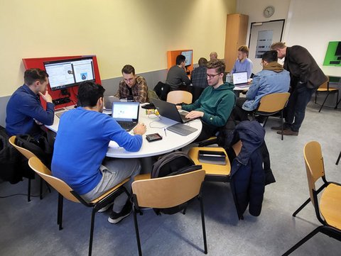 Lehrraum mit Studierenden, die in an Gruppentischen arbeiten