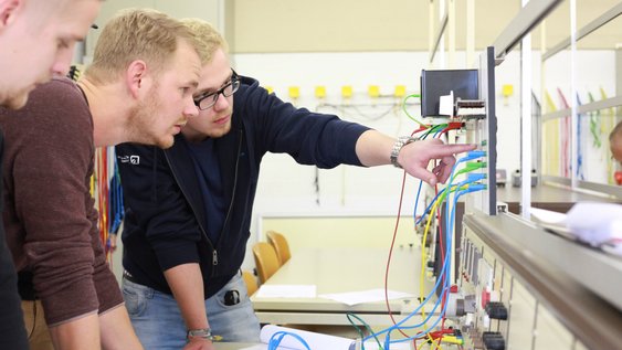 Zwei Studenten stecken Messkabel während einer Laborveranstaltung.