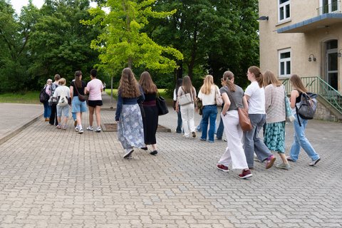 Eine Gruppe Schüler*innen ist von hinten zu sehen, wie sie über den Campus "Am Exer" gehen. (öffnet Vergrößerung des Bildes)