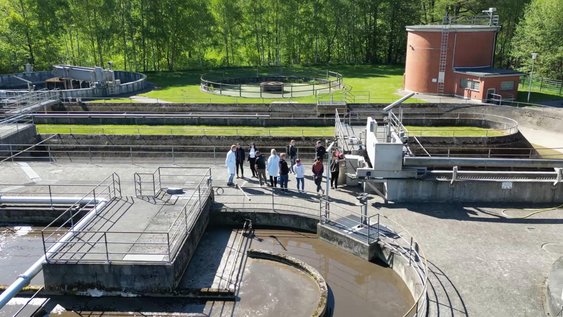 Studierende schauen sich während einer Exkursion eine Kläranlage an., Zwei Studierende betrachten einen Versuchsaufbau in der Wellenrinne der Wasserbauversuchshalle am Campus Suderburg.