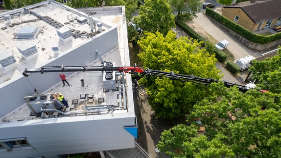 Ein Kran hievt einen neuen Kaltwassersatz auf das Dach den Rechenzentrums in Wolfenbüttel. Die Ostfalia Hochschule investiert in die Klimatechnik und die IT-Infrastruktur.