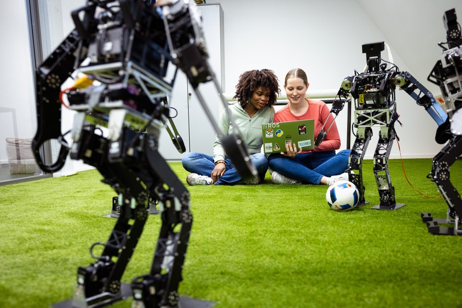 Zwei studentinnen der Ostfalia Hochschule steuern humanoide Roboter, die Fußball spielen. Am Campus Wolfenbüttel kann man unter anderem Informatik studieren.