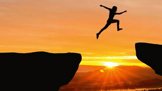 Man jumping on a mountain at sunset. The pose symbolises freedom.