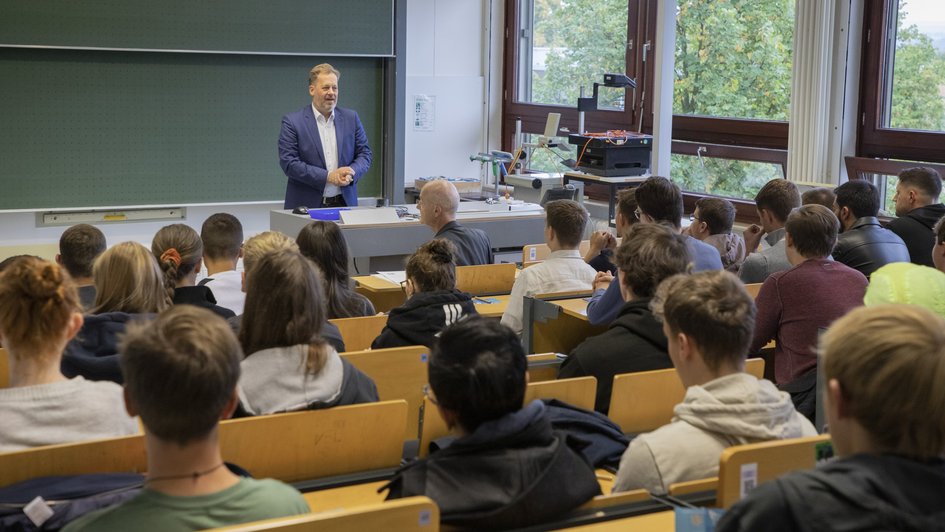 Ein Student und ein Lehrender fotografieren eine Maschine