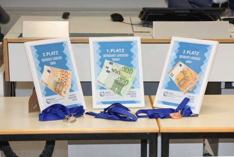 Preisgelder des Energy Awards 2026 in Bilderrahmen. Im Vordergrund sind die Medaillen. (öffnet Vergrößerung des Bildes)