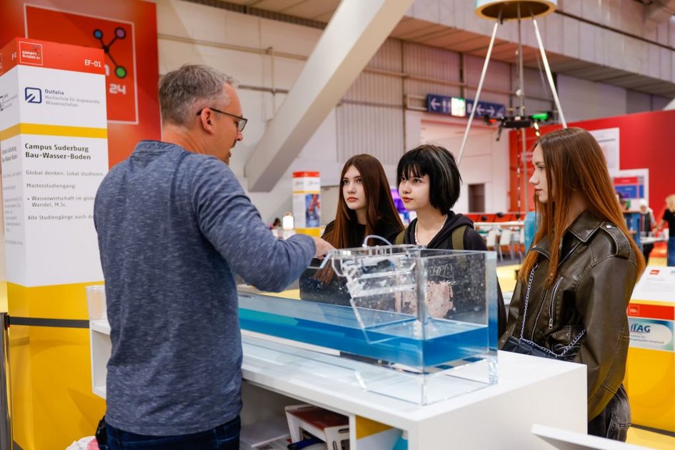 Drei junge Frauen lassen sich den kleinen Wellensimulator der Fakultät Bau-Wasser-Boden der Ostfalia Hochschule erklären