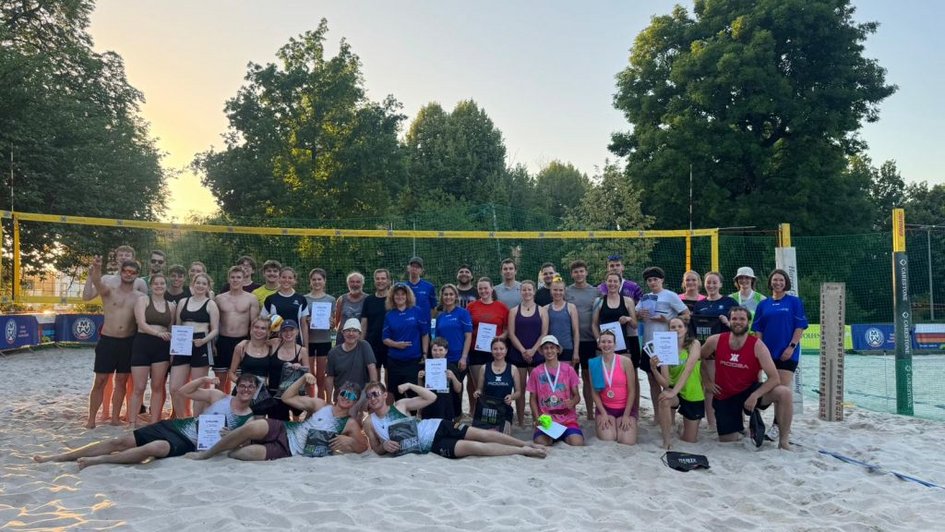 Gruppenfoto alle Teams vor Beachnetz