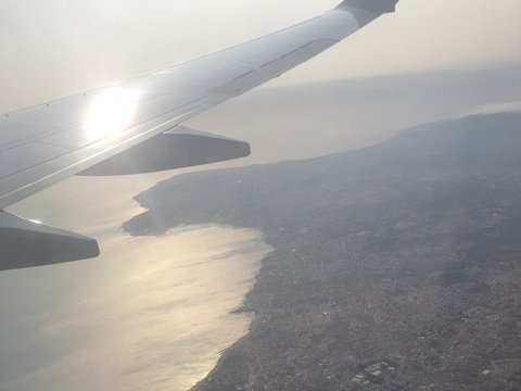 Vogelperspektive aus einem Flugzeug auf eine Landmasse im Sonnenuntergang (öffnet Vergrößerung des Bildes)