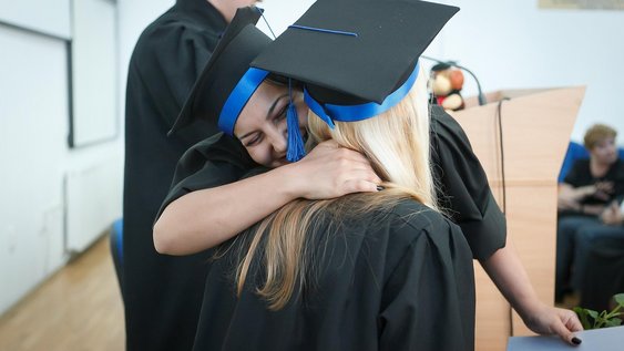 Absolventinnen freuen sich über ihren Abschluss.