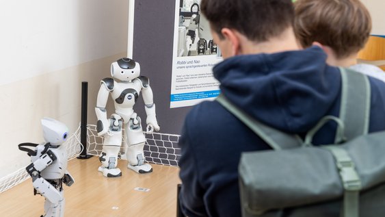 Der NAO-Roboter der Fakultät Maschinenbau und der Roboter Robi der Fakultät für Elektro- und Informationstechnik der Ostfalia Hochschule für angewandte Wissenschaften.